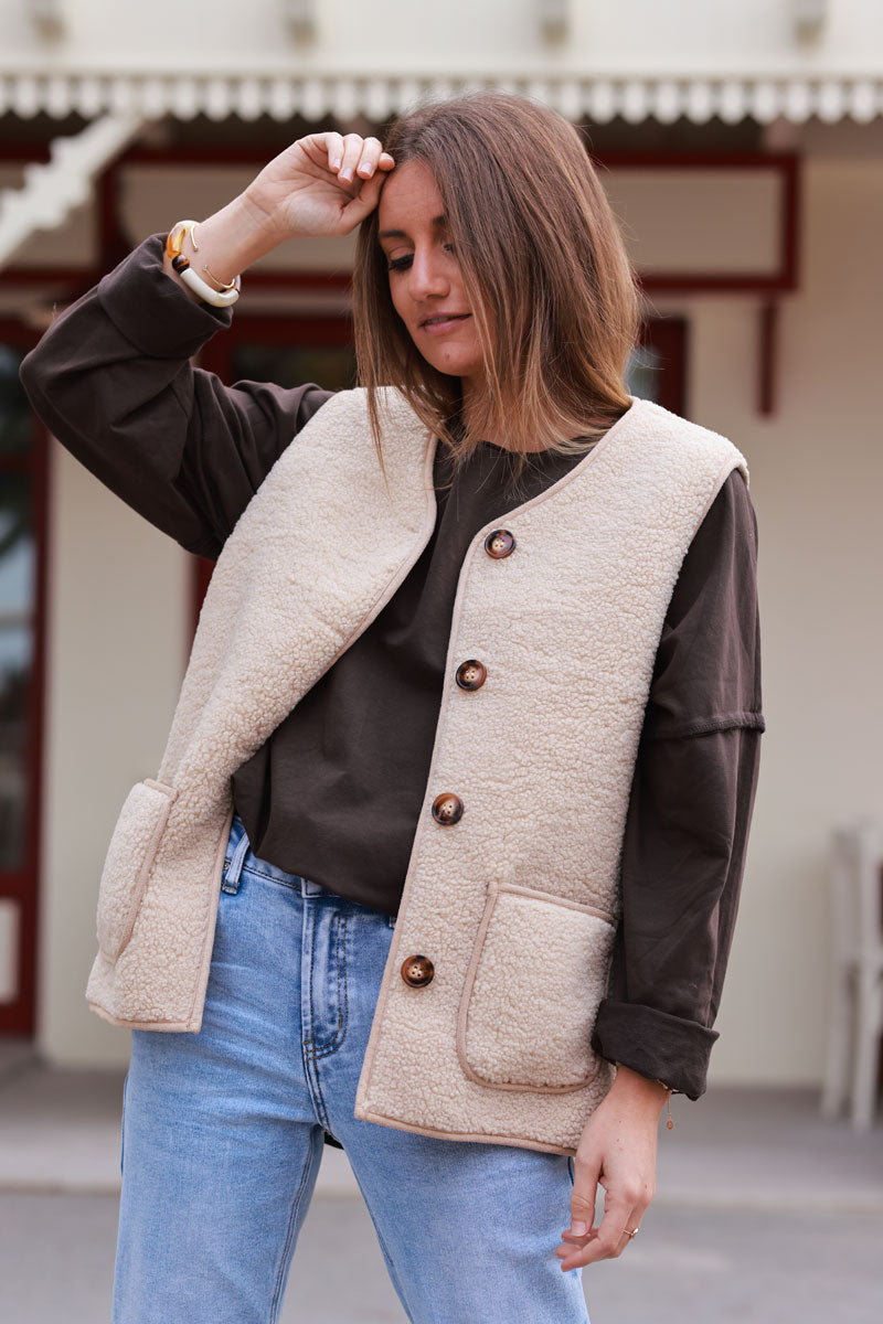 Chaqueta sin mangas con detalle de tupé beige, ribete de botones en carey y bolsillos