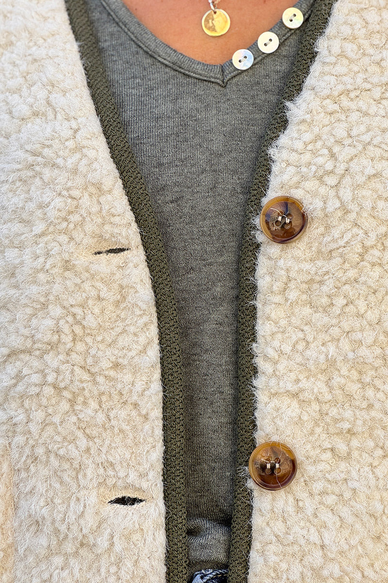 Veste sans manches en moumoute beige détail liseré kaki boutons écaille marron