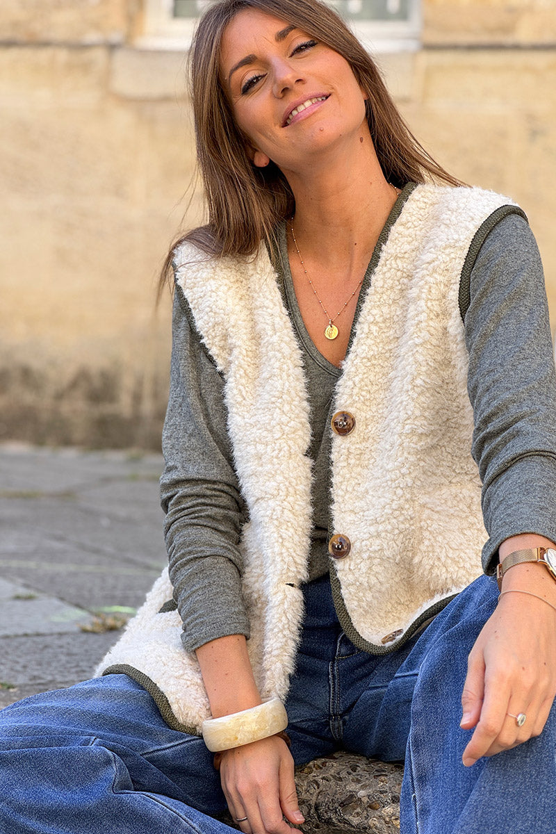 Veste sans manches en moumoute beige détail liseré kaki boutons écaille marron