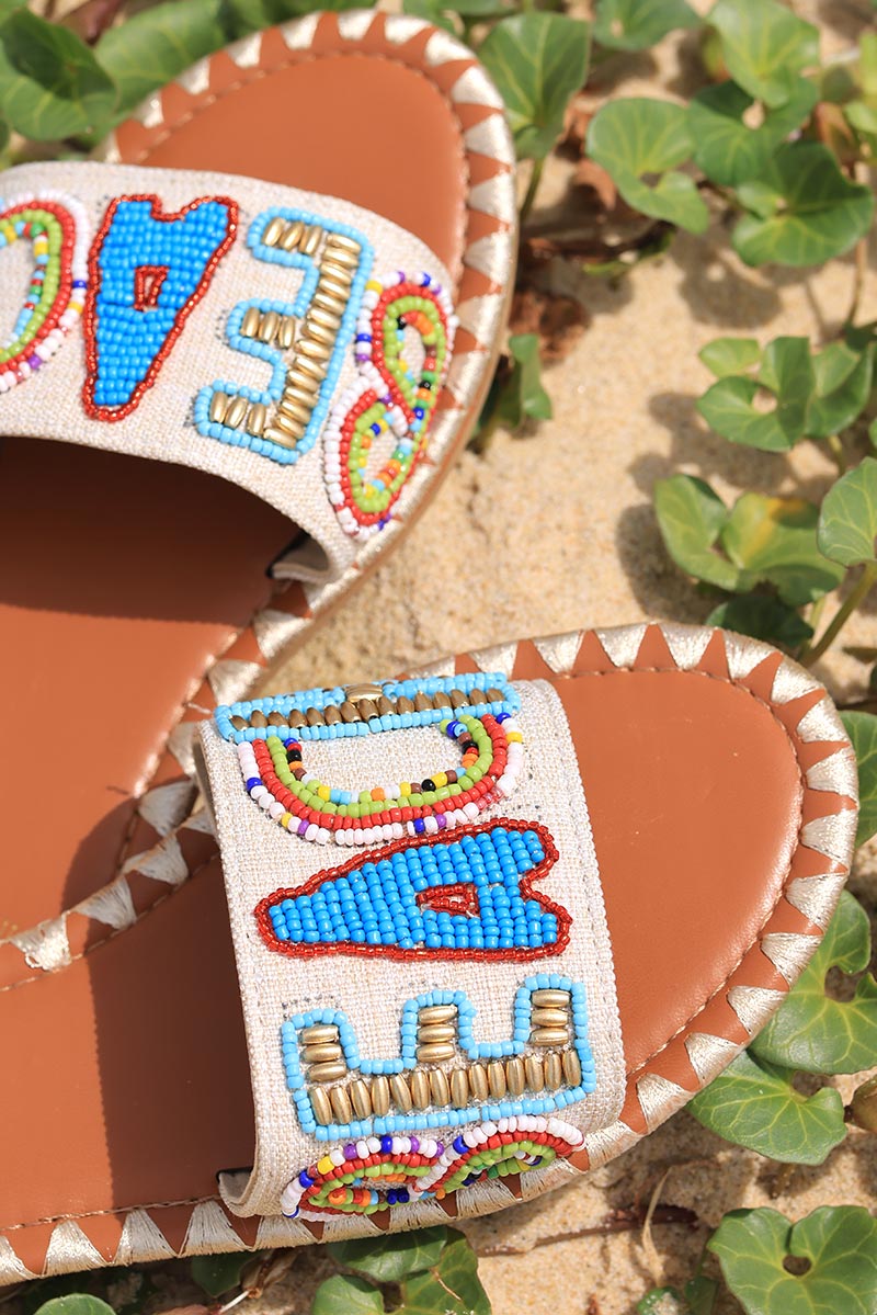 Mules plates large bride tissu beige lettres BEACH en perles multicolores